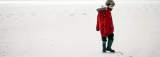 Kind läuft allein durch den Schnee