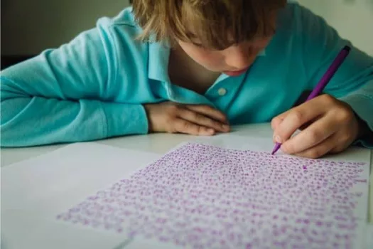 Asperger-Feinmotorik: Junge schreibt seine Hausaufgaben