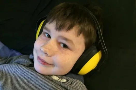 Asperger-Junge mit geräuschdämmenden Kopfhörern