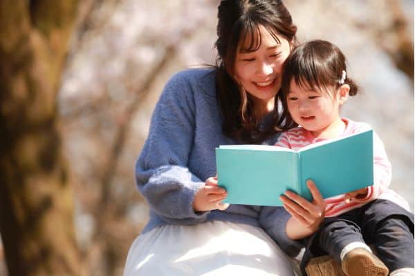 Social Stories: Mutter und Tochter lesen ein Buch (Symbolbild)
