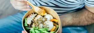 Ein Mann isst Essen aus einer Schale