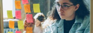 Eine Frau plant mit Post-It-Notizen.