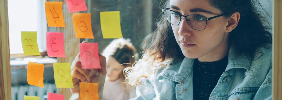 Eine Frau plant mit Post-It-Notizen.