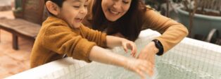 Mutter und Kind spielen mit Wasser